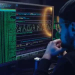 A developer looking at a computer screen with code, representing the Mashvisor, AirDNA, and Zillow API as top real estate data APIs in 2025